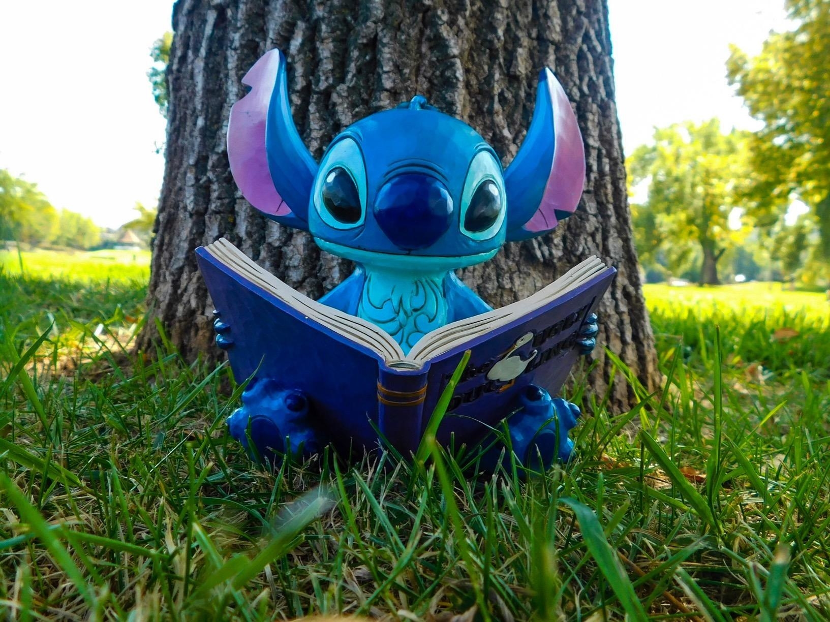 a figure of stitch reading the ugly duckling book