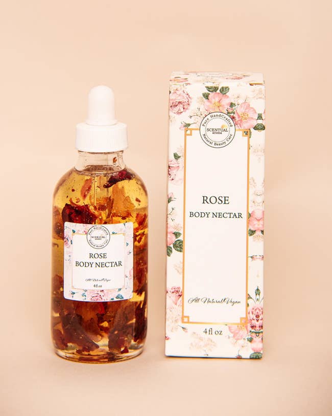 small glass bottle of oil with rose petals in side