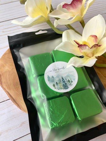 six green-wrapped shower steamers in their packaging 