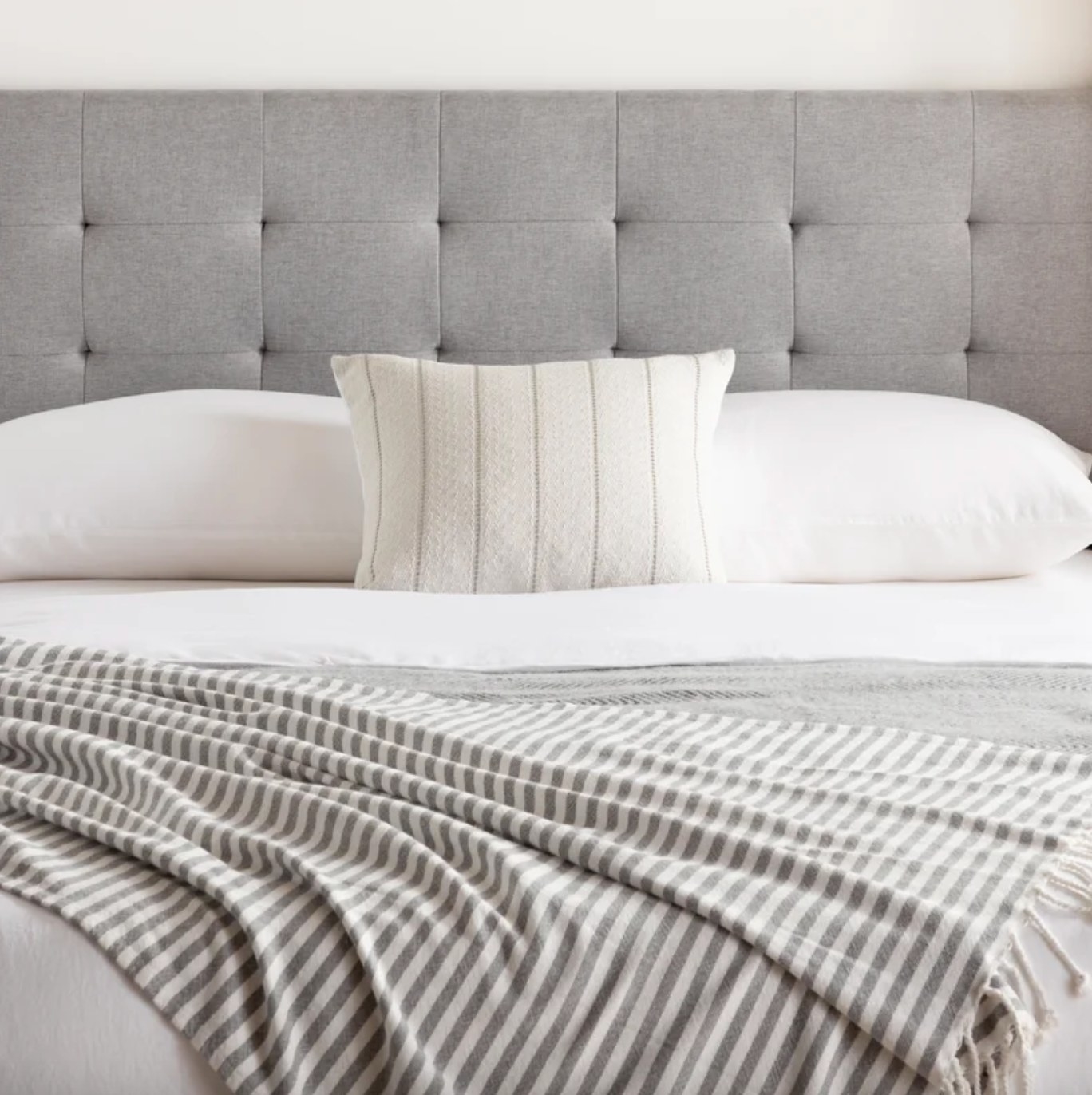 The upholstered headboard in stone