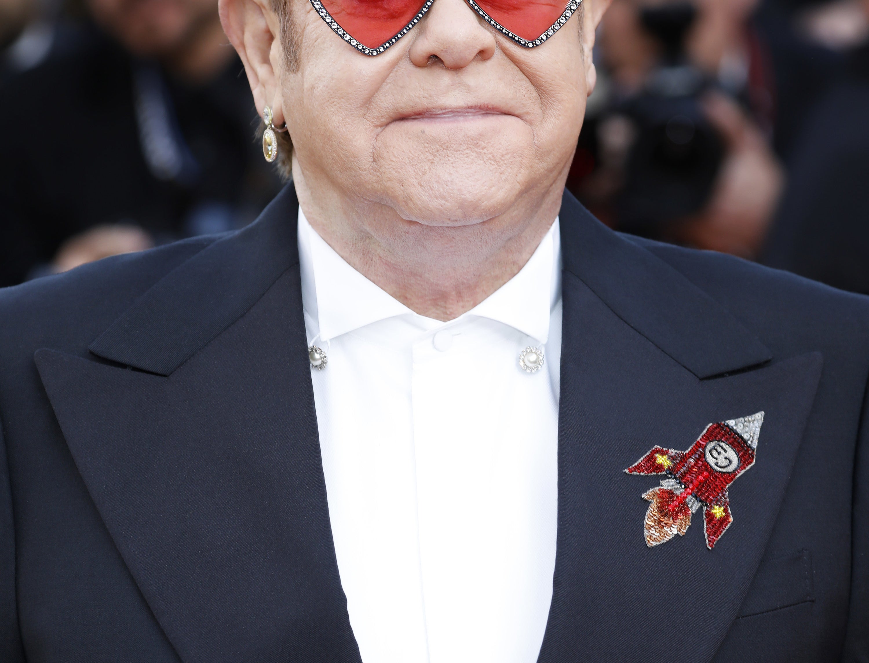 Elton John in heart-shaped sunglasses and a suit