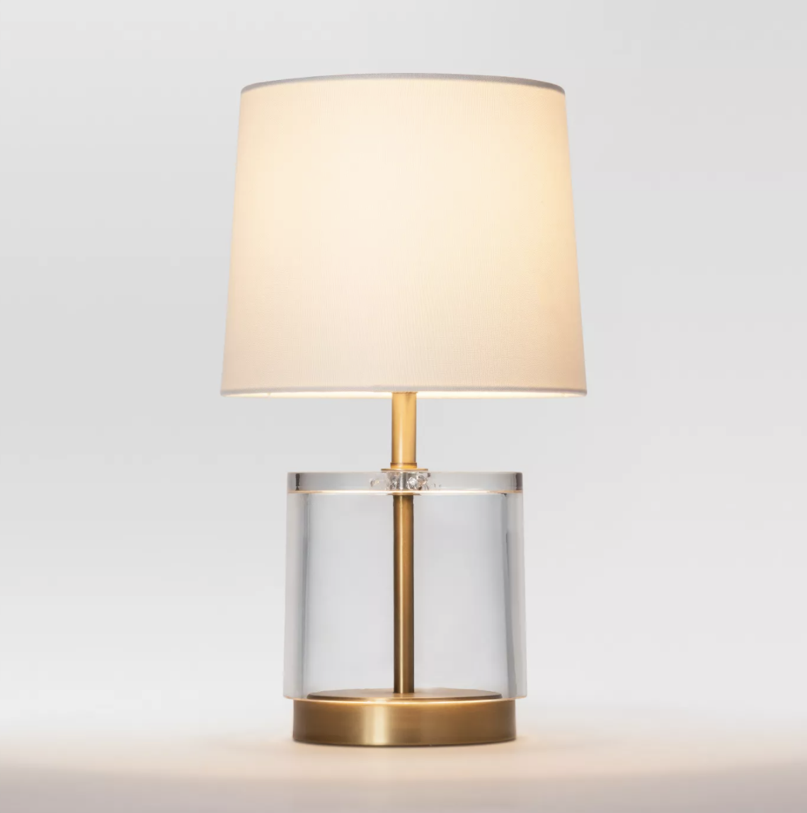 the acrylic and brass table lamp with a beige lampshade
