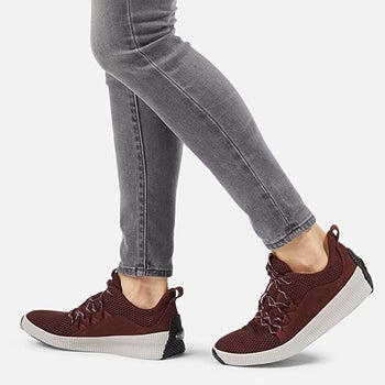 model wearing the sneakers with gray skinny ankle jeans