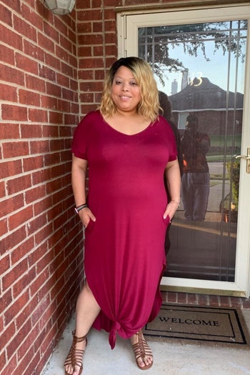 A reviewer wearing a red maxi dress