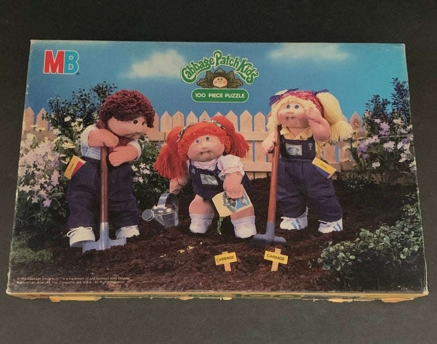 A puzzle box featuring three Cabbage Patch Kids planting a garden 