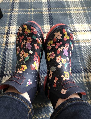 reviewer wearing the ankle boots with a floral pattern