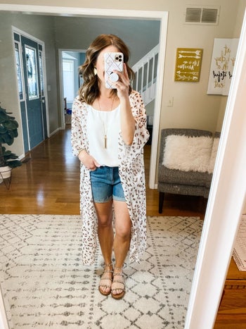 Reviewer wearing cardigan over a shirt and shorts