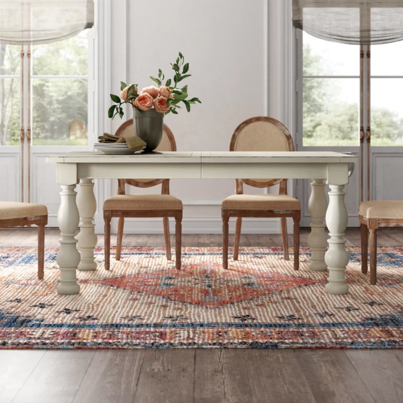 The extendable dining table in white holding a vase of flowers