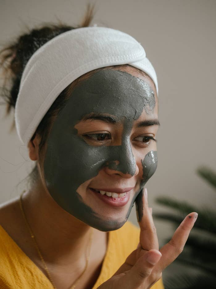 A woman putting on a facial mask