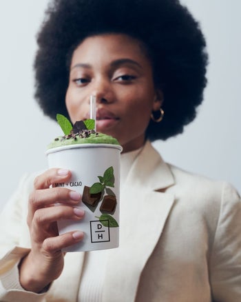 a model holding a mint smoothie