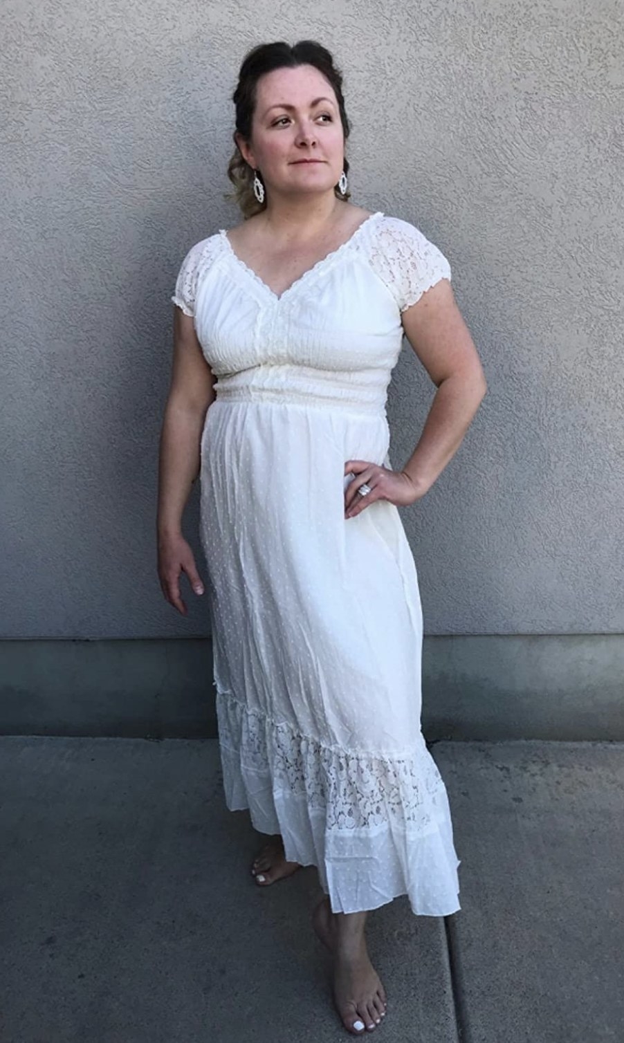a reviewer wearing the midi length dress in ivory