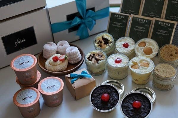pudding cups, brownies, cookies, and other desserts on a table