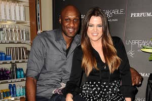 Lamar Odom and Khloe Kardashian sit next to each other at an event in 2012