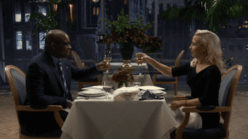 A couple having dinner and clinking glasses at a fancy restaurant
