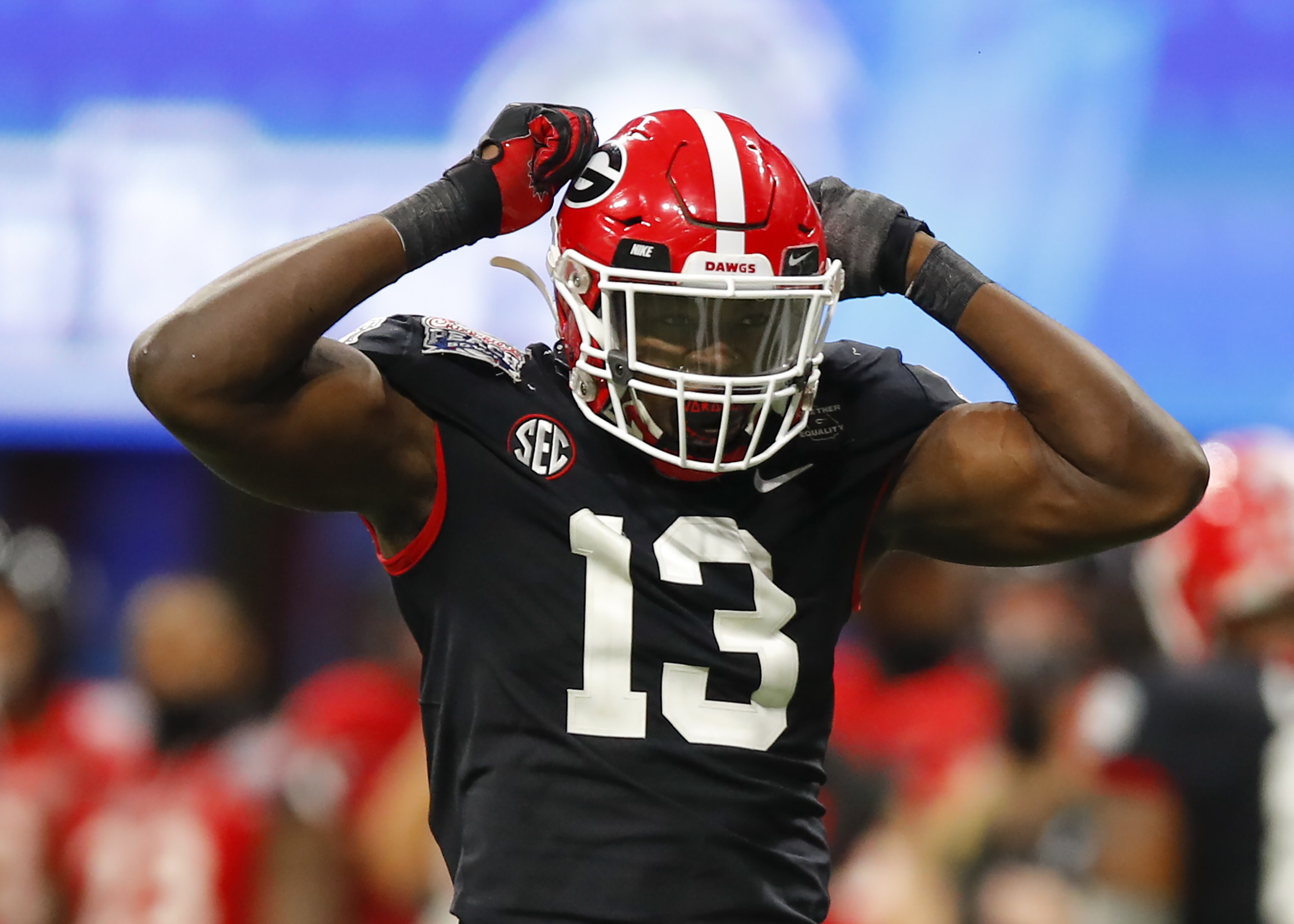 Azeez Ojulari with his hands on his helmet