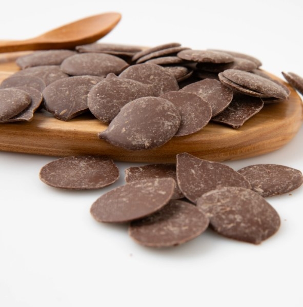 A pile of carob buds on a wooden platter