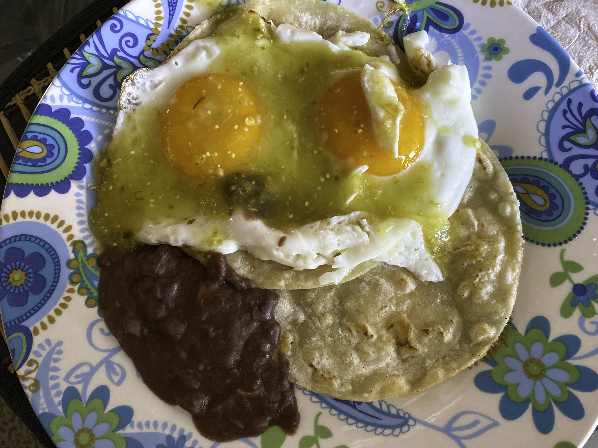 Sunny-side up eggs on top of tortillas and beans.