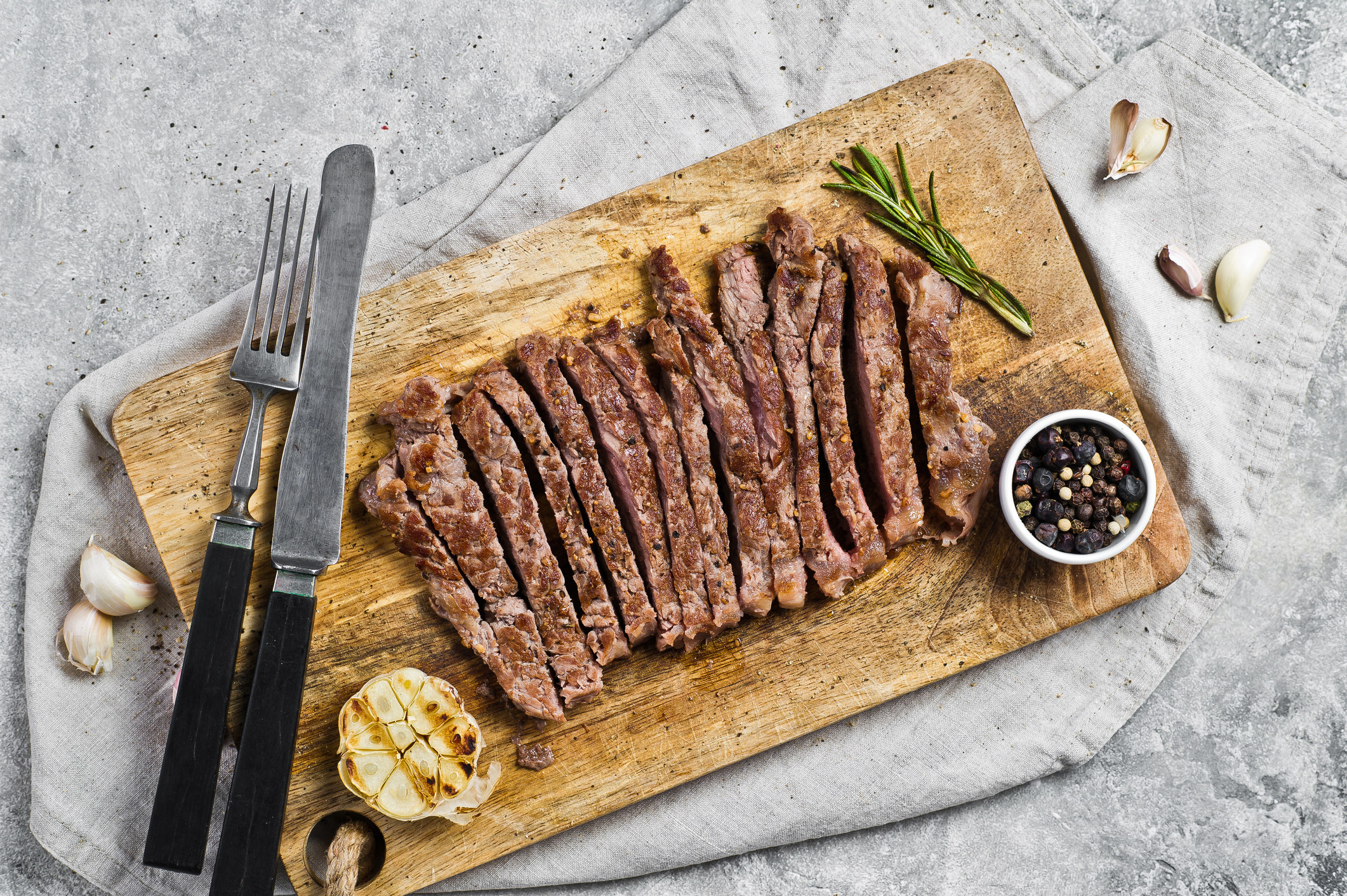 A cutting board topped with sliced steak.