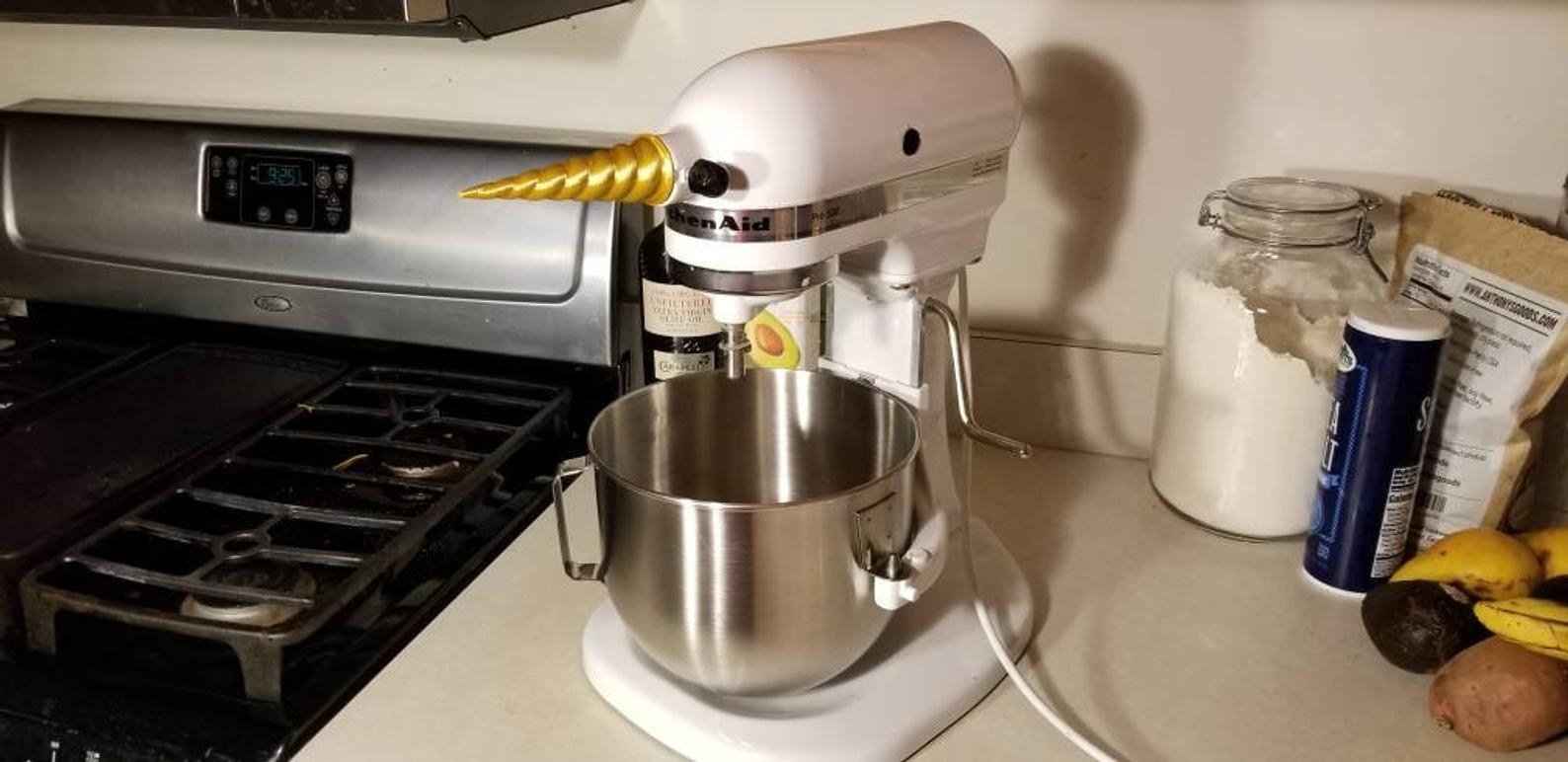 kitchen countertop with a Kitchen-Aid mixer with a gold unicorn horn stuck on the front of it