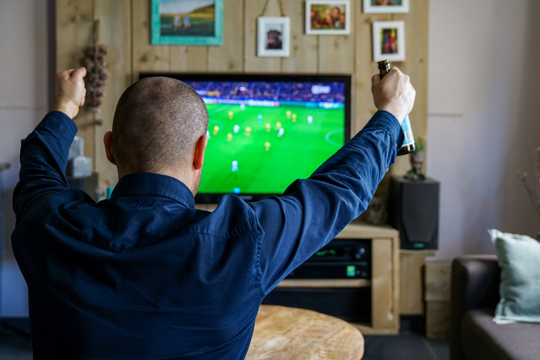 guy cheering at soccer match on TV