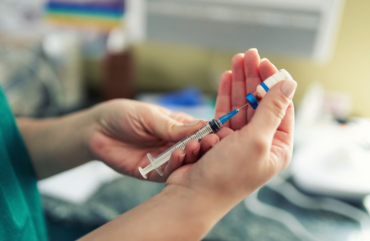 two hands holding a vaccination