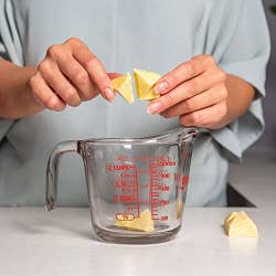 a model breaking up the concentrate in a measuring cup 
