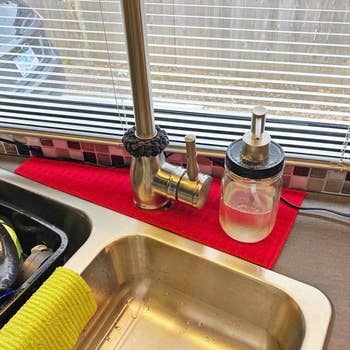 red absorbent mat around a kitchen faucet