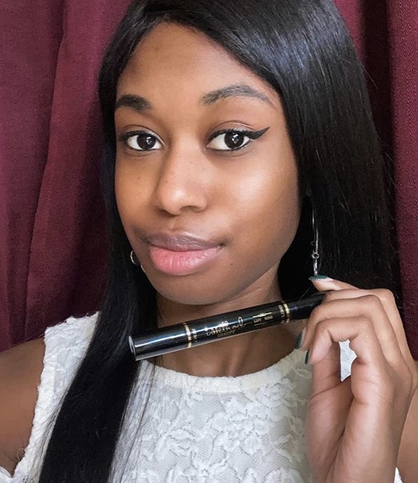 A reviewer photo wearing black liquid eyeliner and holding the eyeliner pen