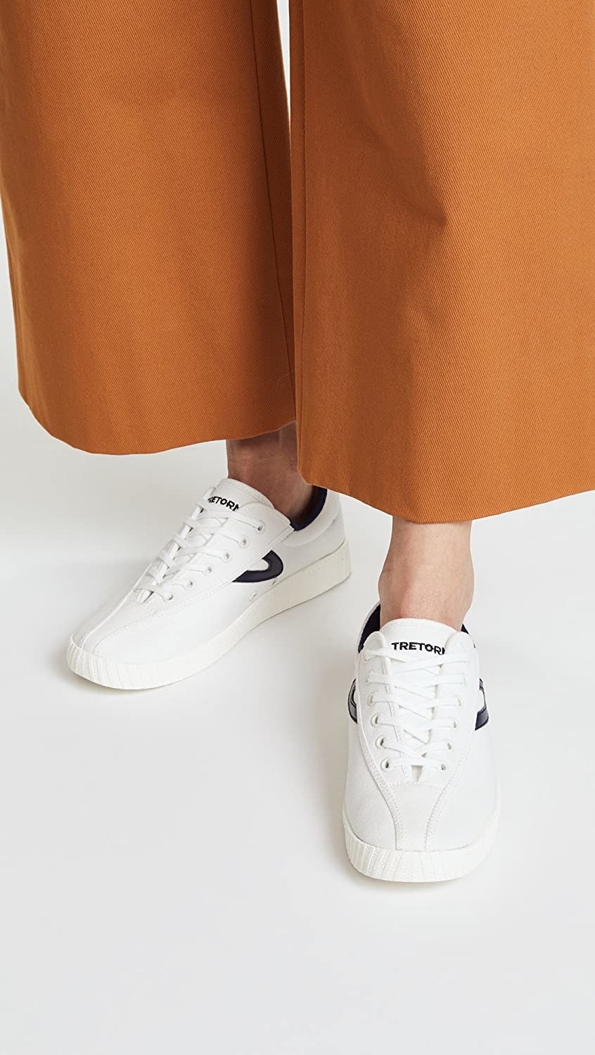 Reviewer wearing the sneakers in white with wide leg dress pants 