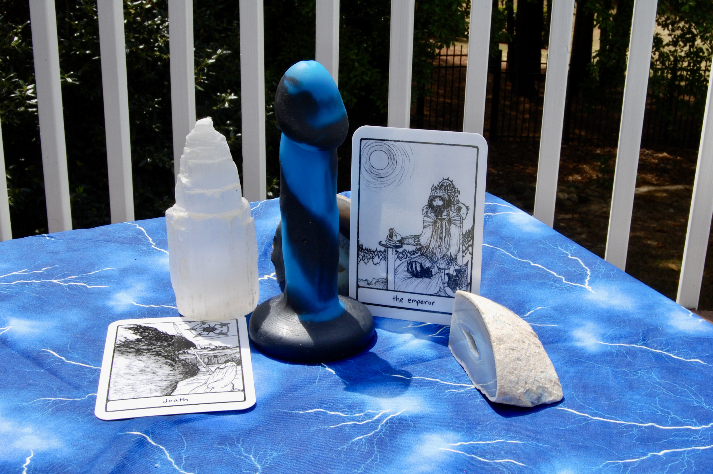 Photo of black and blue Shilo dildo with two tarot cards (the Emperor and Death), plus two geodes and a selenite tower