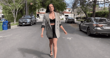 gif of Sarah wearing blazer with bralette and biker shorts