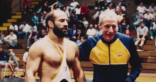 John du Pont coaching Dave Schultz in a wrestling match