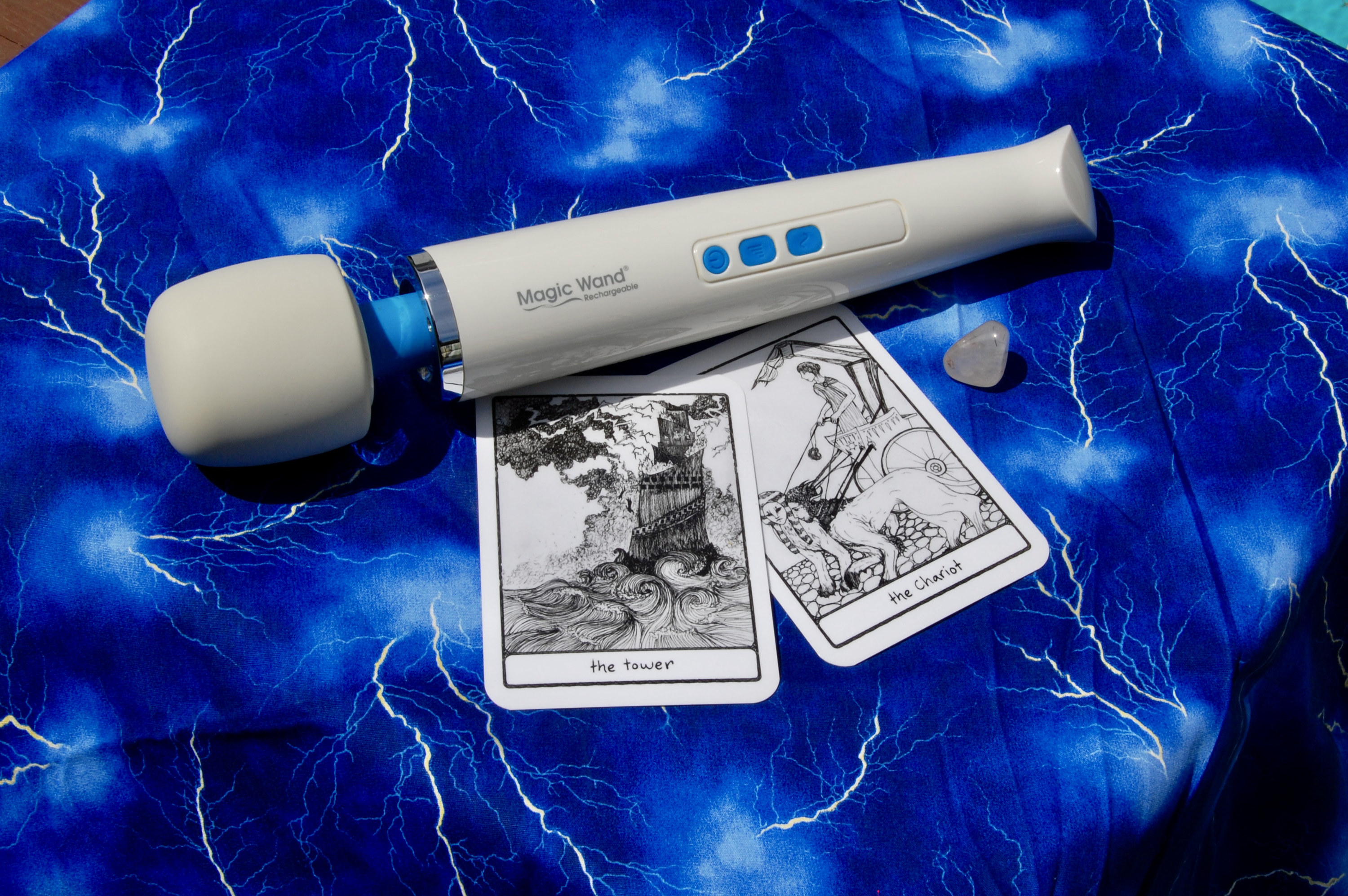 Photo of the Magic Wand Rechargeable with two tarot cards (the Tower and the Chariot), plus a small crystal