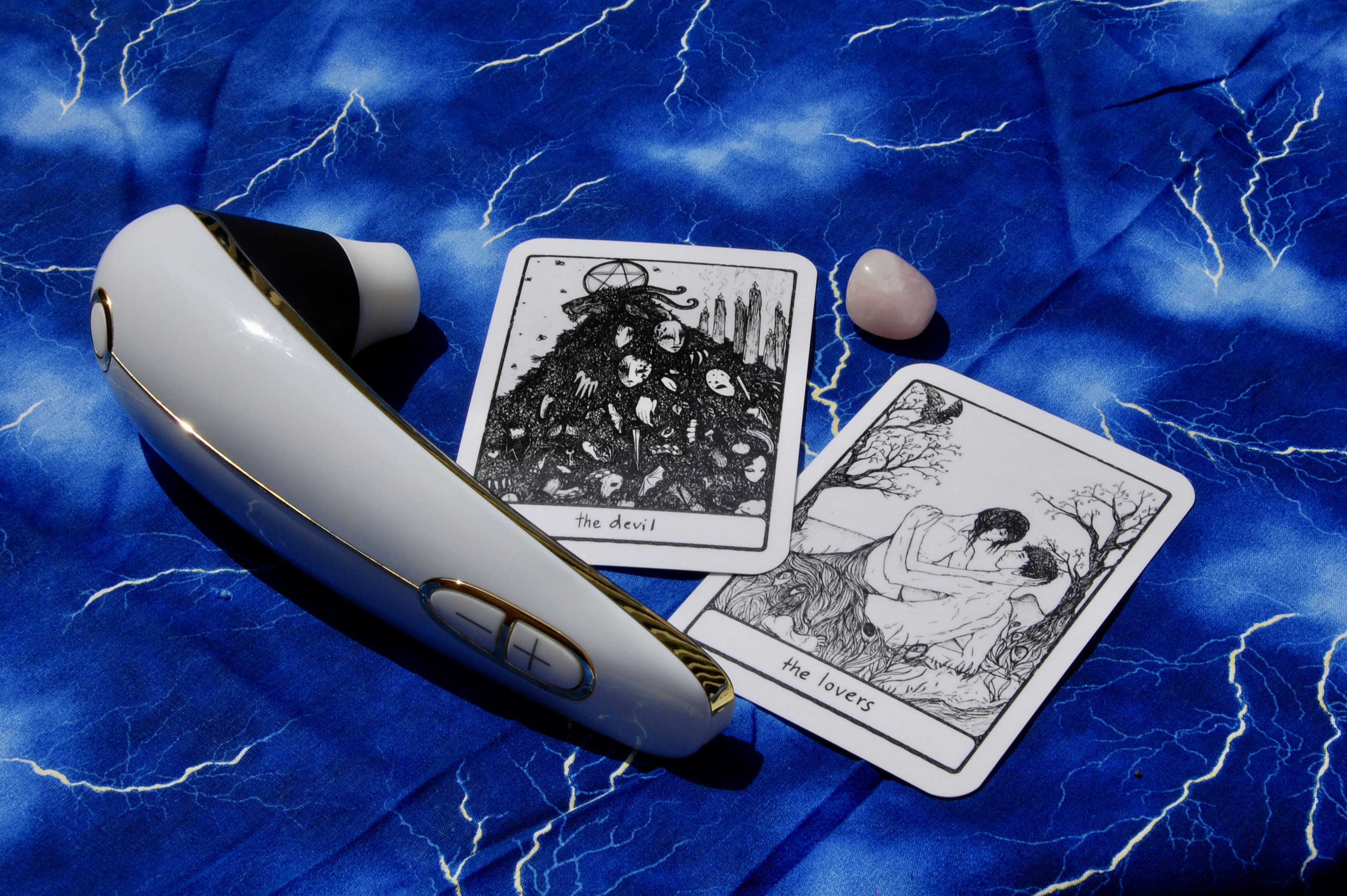 Photo of the Womanizer with two tarot cards (the Devil and the Lovers), plus a small crystal