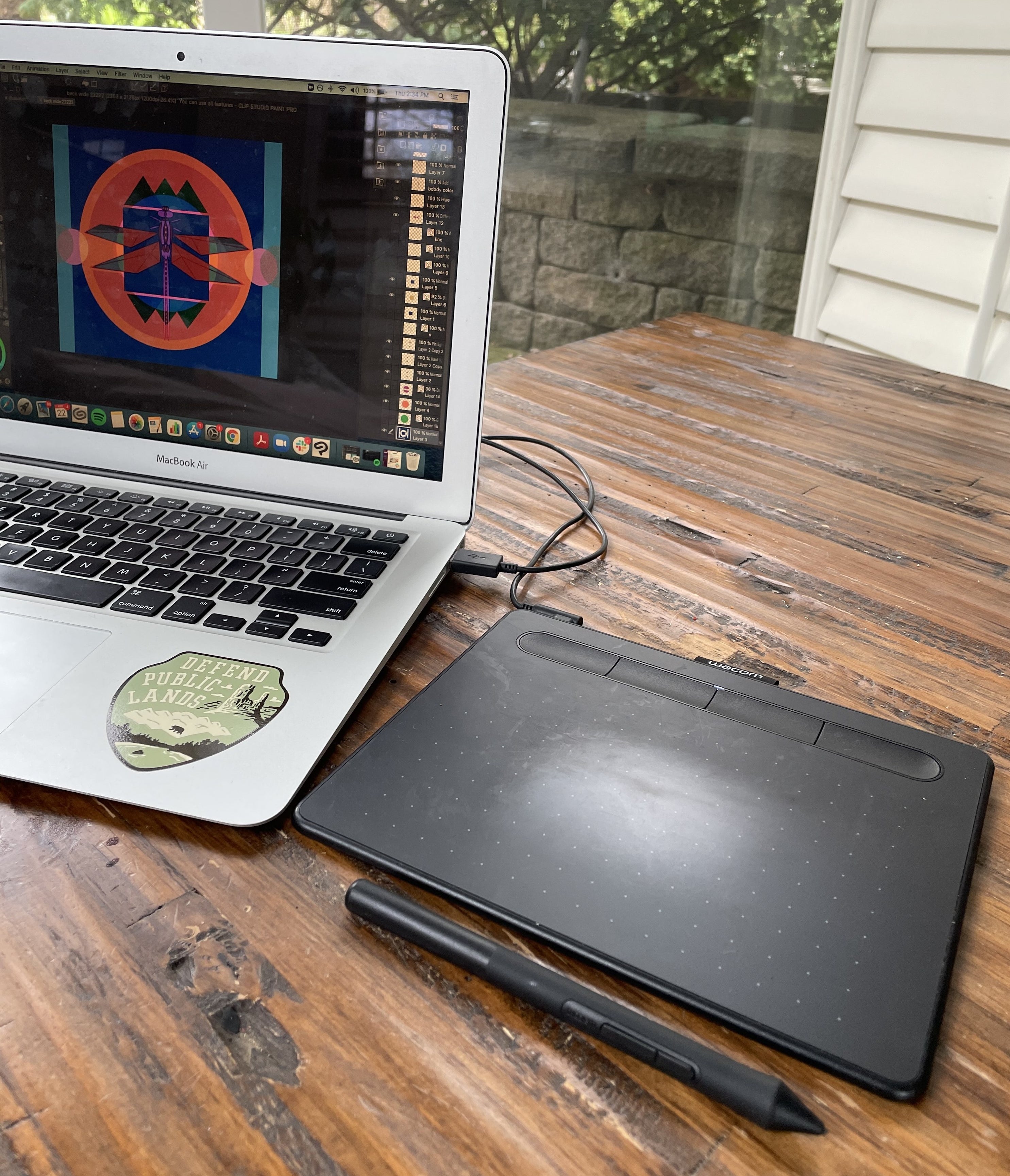 The wacom drawing tablet and stylus plugged into a laptop 