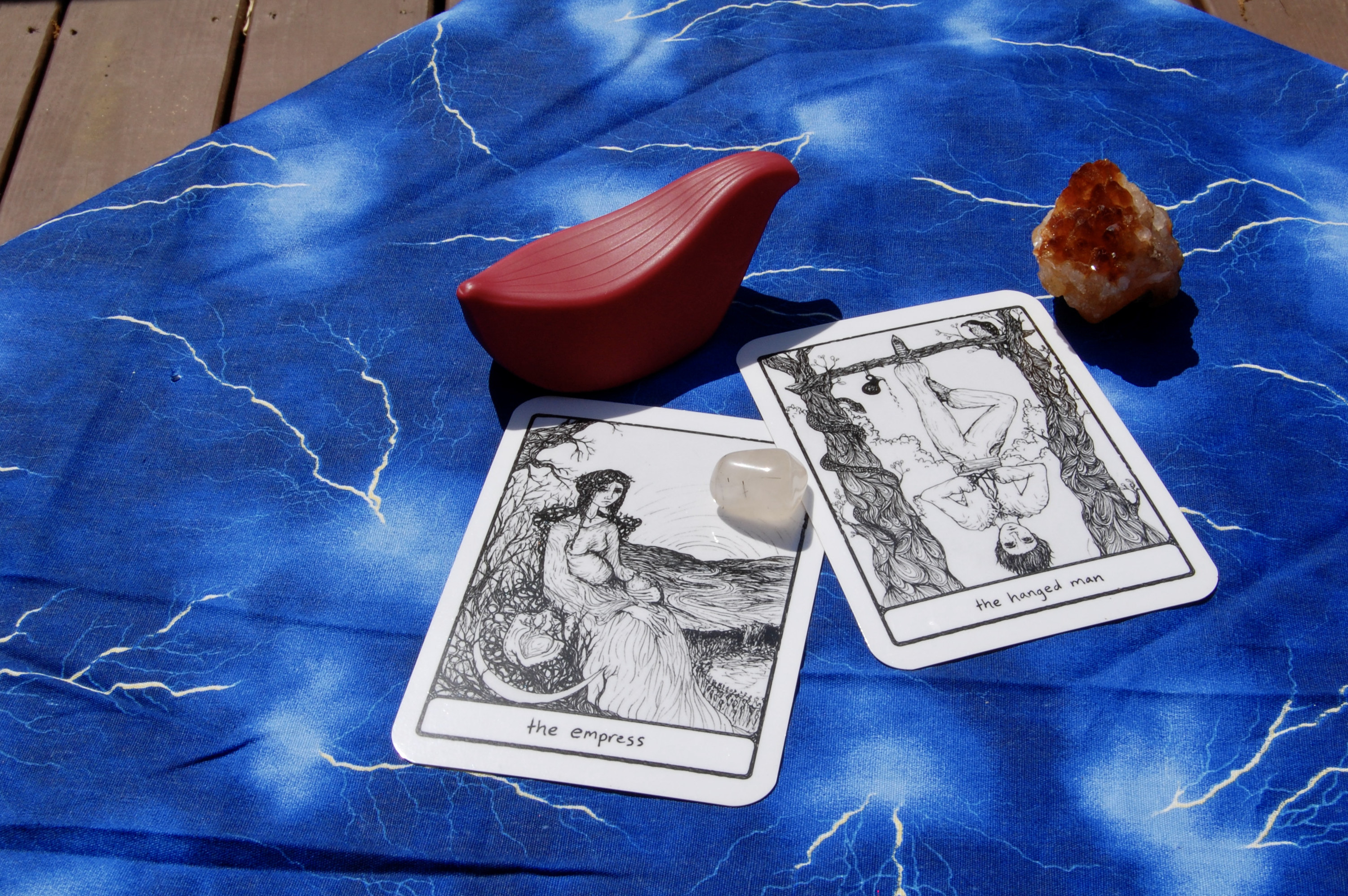 Photo of Iroha Tori with two tarot cards (the Empress and the Hanged Man), plus two small crystals