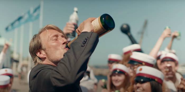 Mads Mikkelsen drinking champagne out of the bottle in &quot;Another Round&quot;