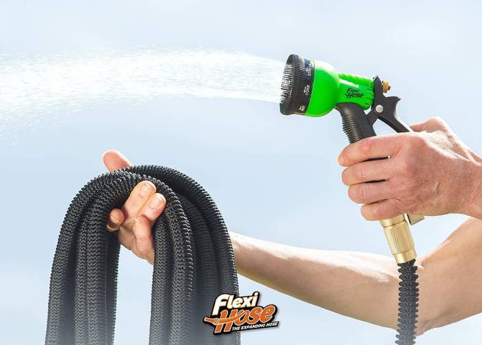 hand holds pile of hose with a spray nozzle 