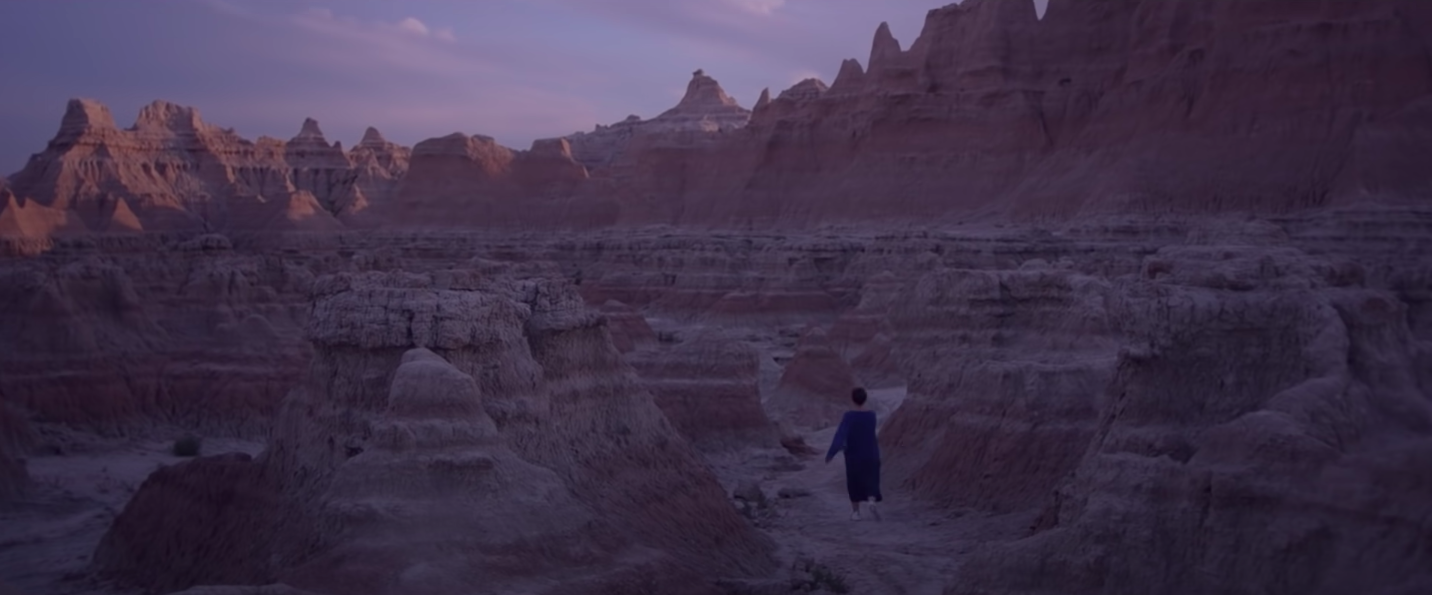 Frances McDormand walking through the Badlands in "Nomadland"