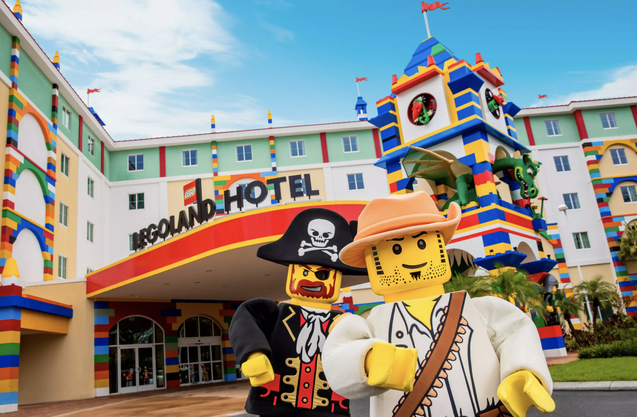 A hotel that looks like it&#x27;s made from Lego, with two Lego characters in the foreground