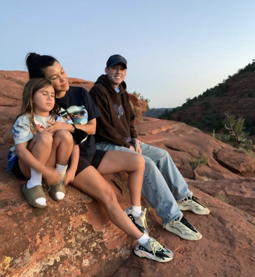 Harry sits on a rock with Kourtney and her daughter Penelope