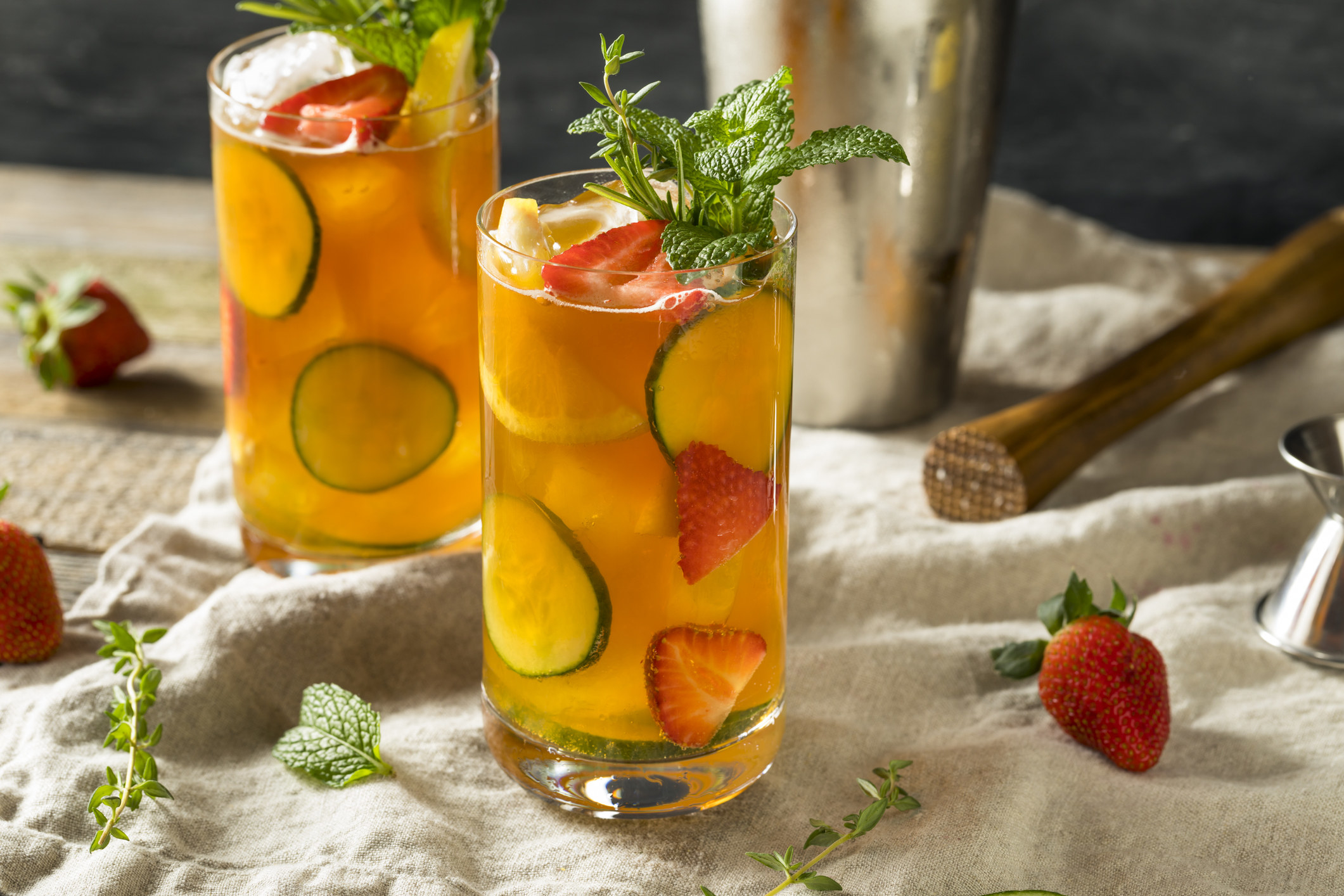 Two Pimm&#x27;s Cups with lime and strawberries.