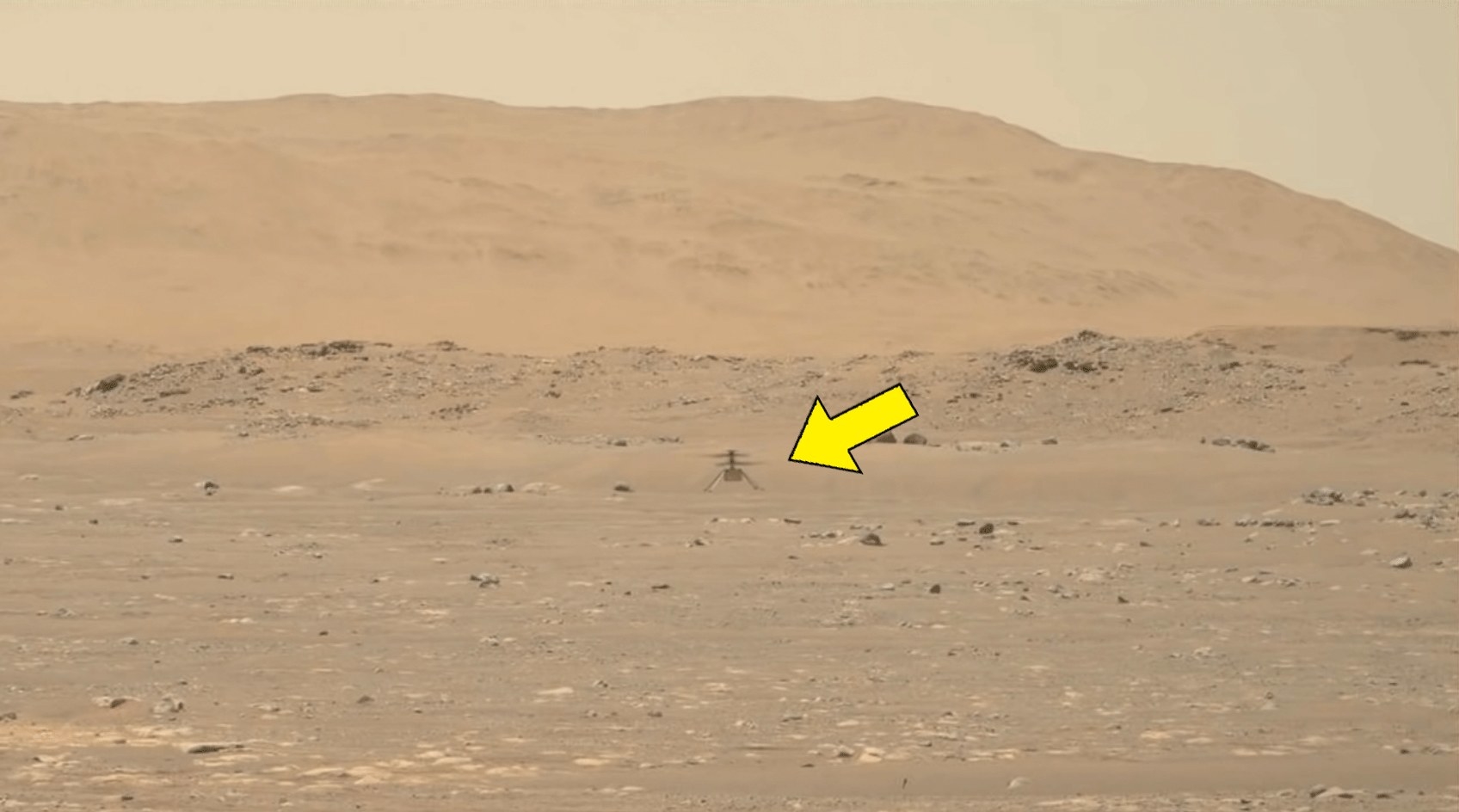 Ingenuity hovering above the surface on Mars