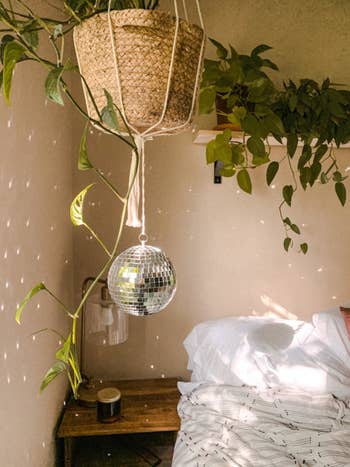 Reviewer image of hanging disco ball with the light hitting it in a bedroom 