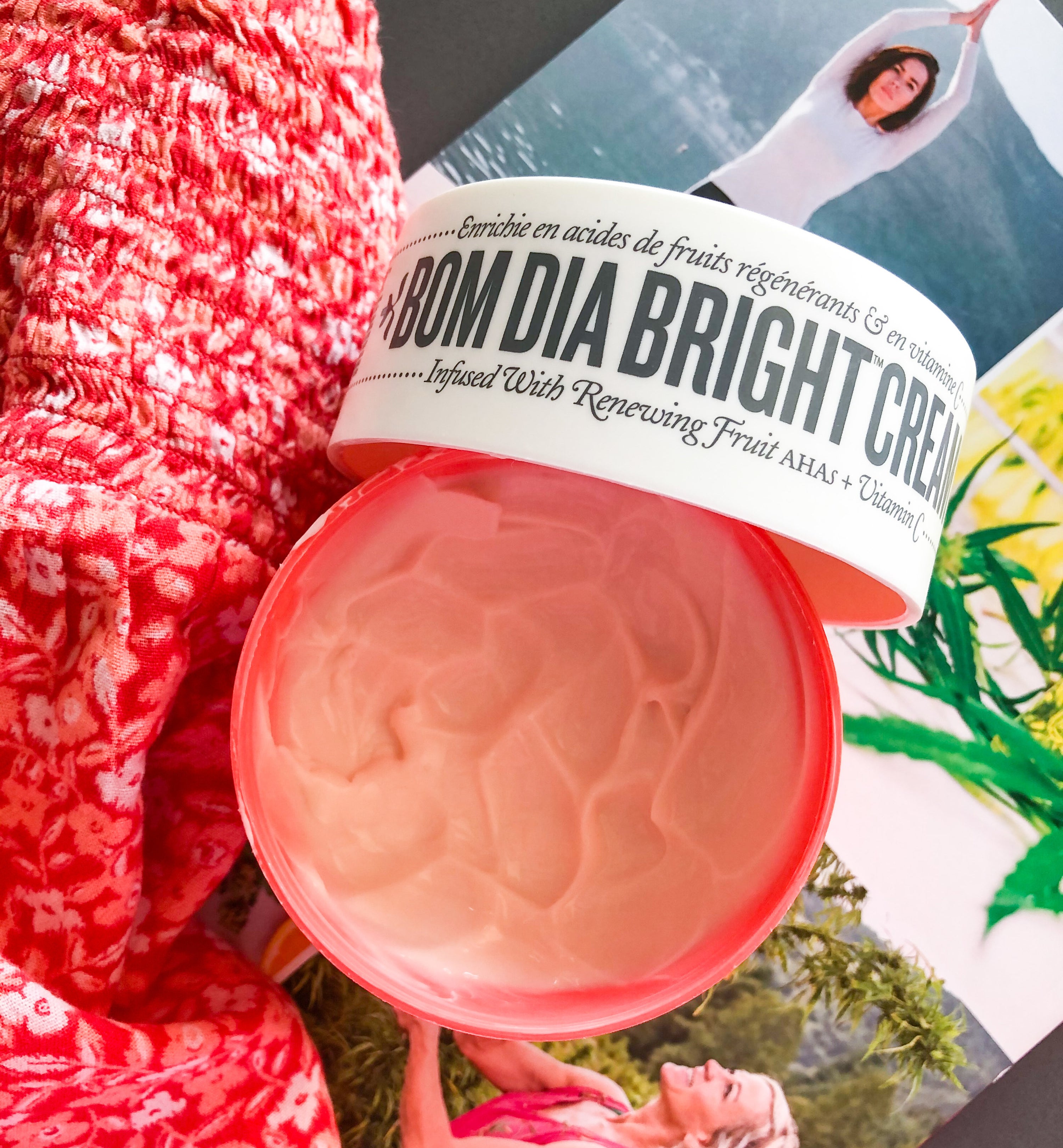 A flatlay of an open tub of the body lotion showing off it's texture