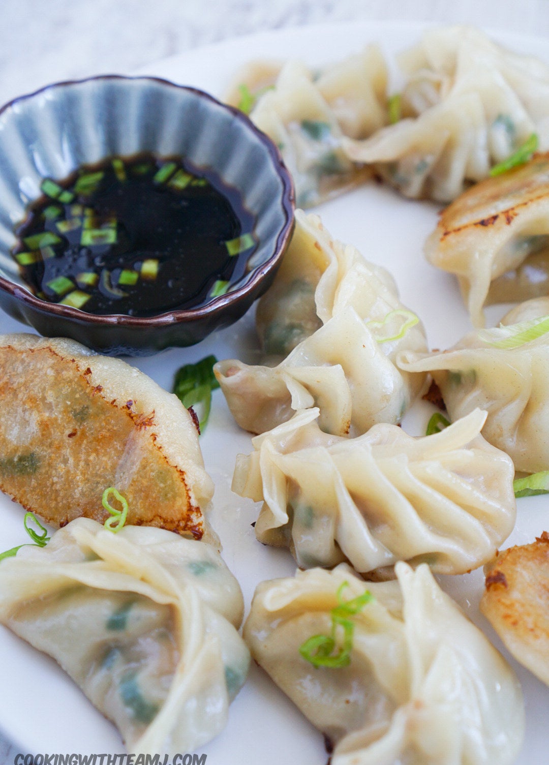 Pork and chive steamed dumplings with soy sauce on the side.
