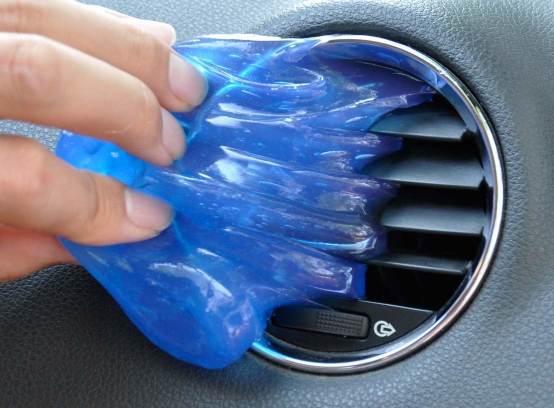 The slime being used to clean a car AC vent.