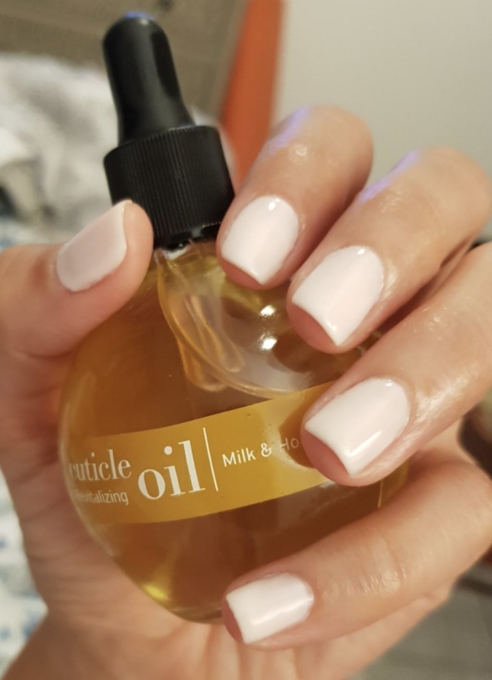 A person holding the cuticle oil