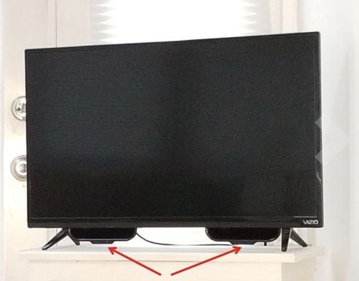 A reviewer&#x27;s television with two black &quot;scoops&quot; installed on the bottom of the screen 