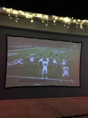 reviewer close-up of the screen with a football game projected onto it